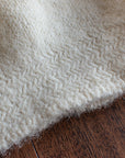 a close up shot of the herringbone detail at the edge of a felted knit hat