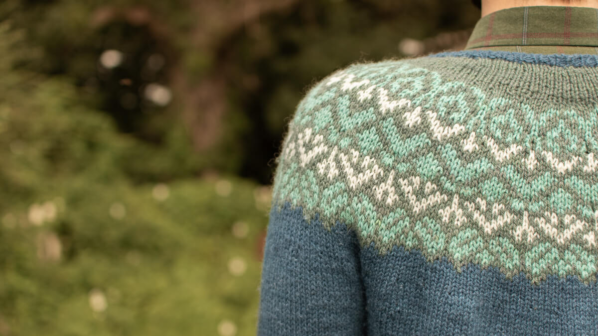 Close up of hand-knitted colourwork yoked jumper in hand-dyed yarn