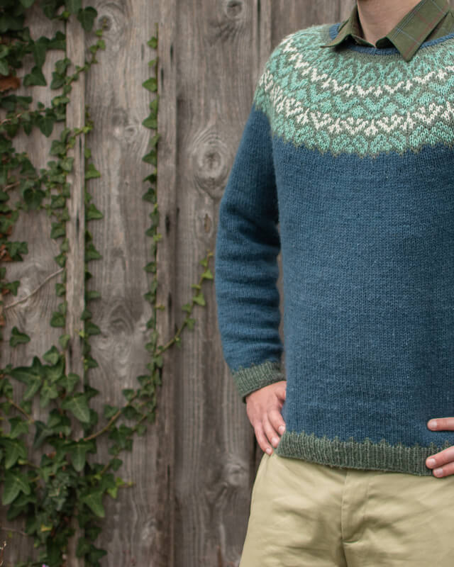 Close up of hand-knitted colourwork yoked jumper in hand-dyed yarn