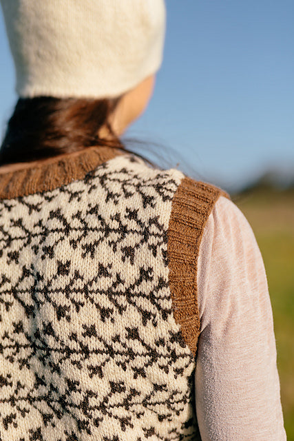 a close up shot of the shoulder and branch like colourwork detail on a handknit tank top 
