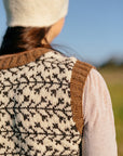 a close up shot of the shoulder and branch like colourwork detail on a handknit tank top 